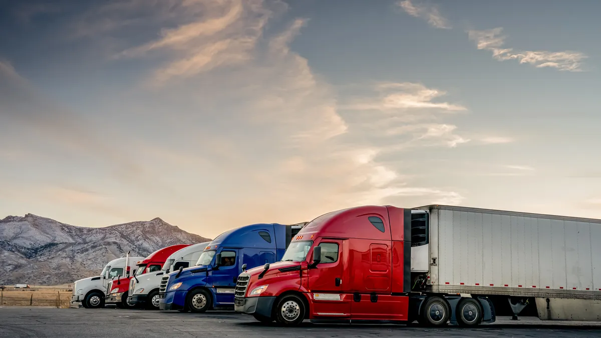 Trucks are parked in front of a mountain landscape.