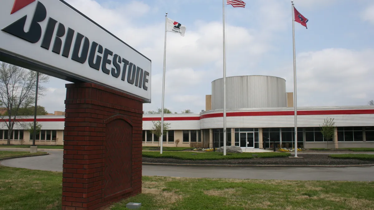 The white, black and red Bridgeston sign in front of a building.