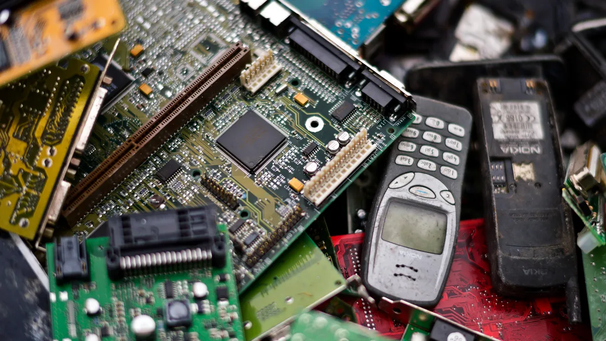 A close up of cell phones and circuit boards awaiting recycling