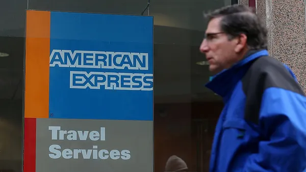 A pedestrian walks by an American Express Travel Services office.