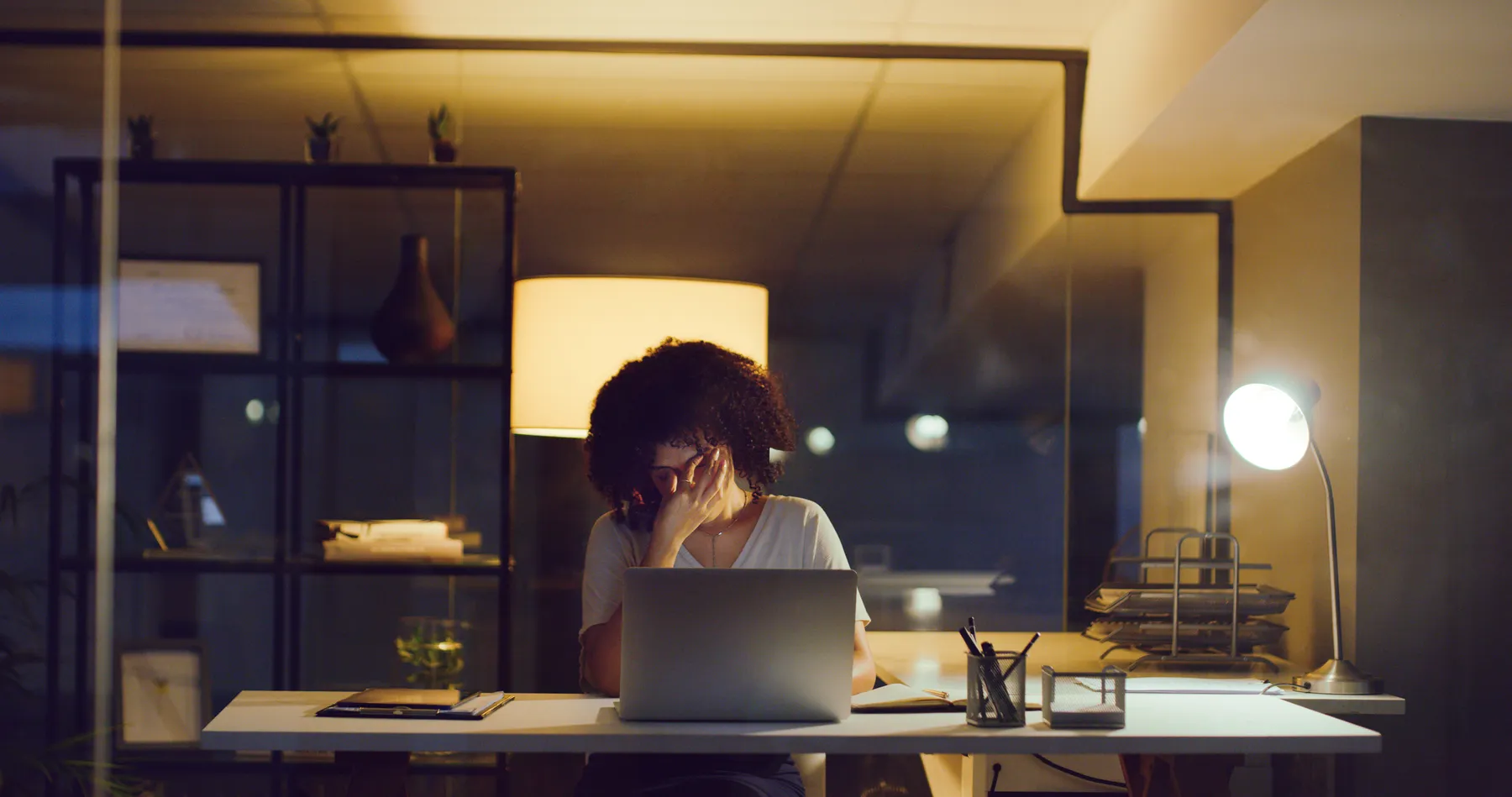 Shot of a young businesswoman looking stressed while using a laptop during a late night at work.