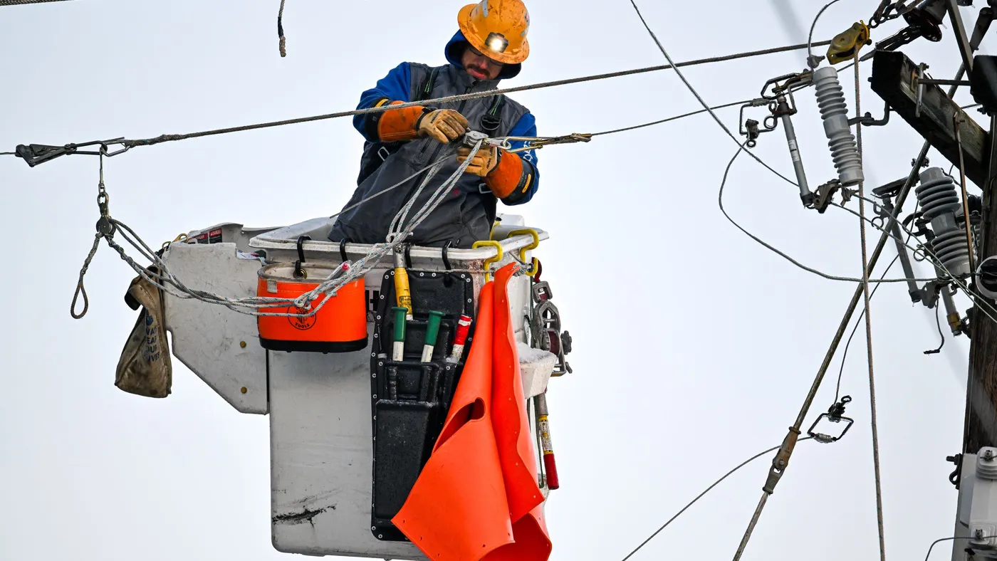 A worker repairs a power line