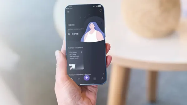 A hand holds a smartphone displaying an app with a calming design, featuring an illustration of a relaxed person and weather forecasts. Background is softly blurred.