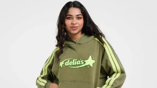 A green and yellow Delia's Target collection hoodie on a brunette model