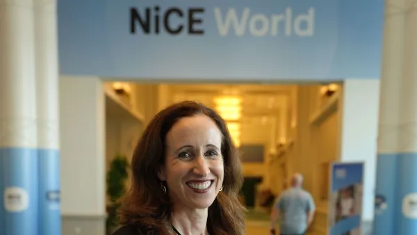 woman standing in front of a sign that says Nice World