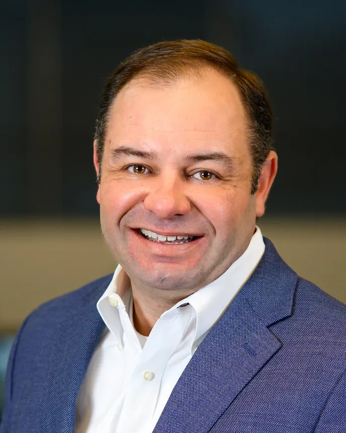 A headshot of Travis Mrss