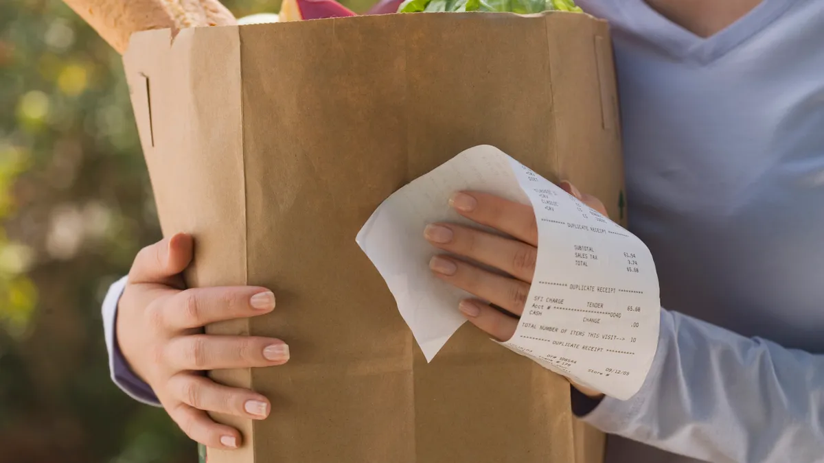 Woman holding grocery bag and receipt