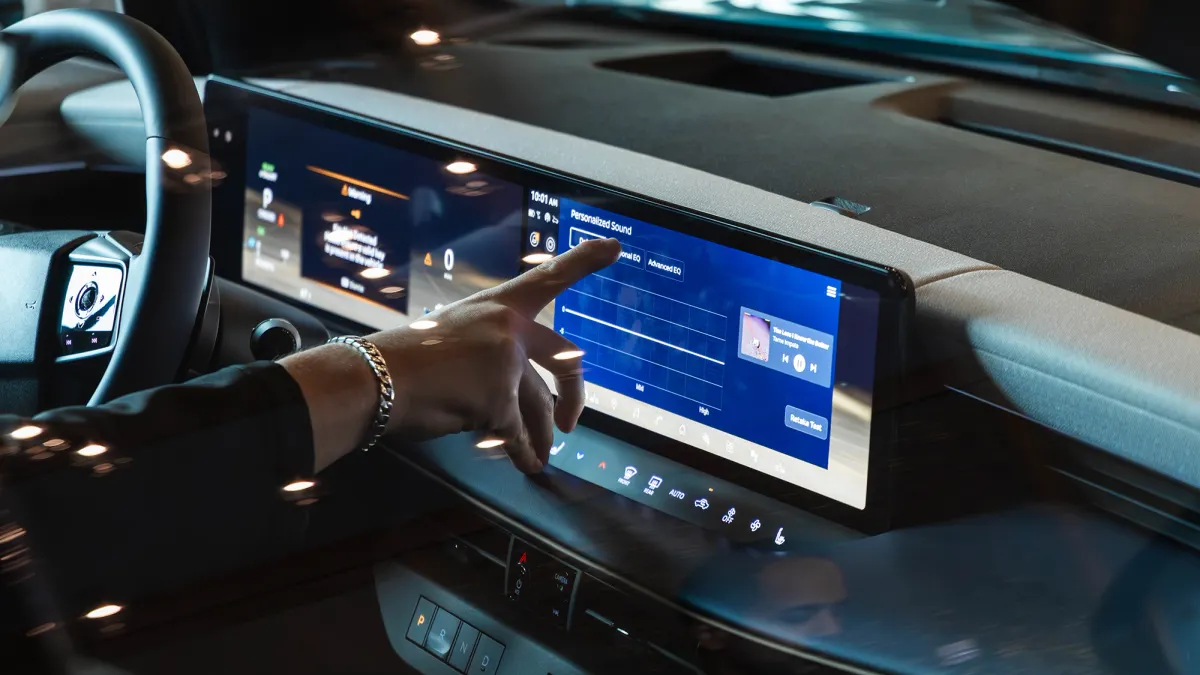 A driver touching the infotainment screen in a 2026 Nissan Leaf EV.
