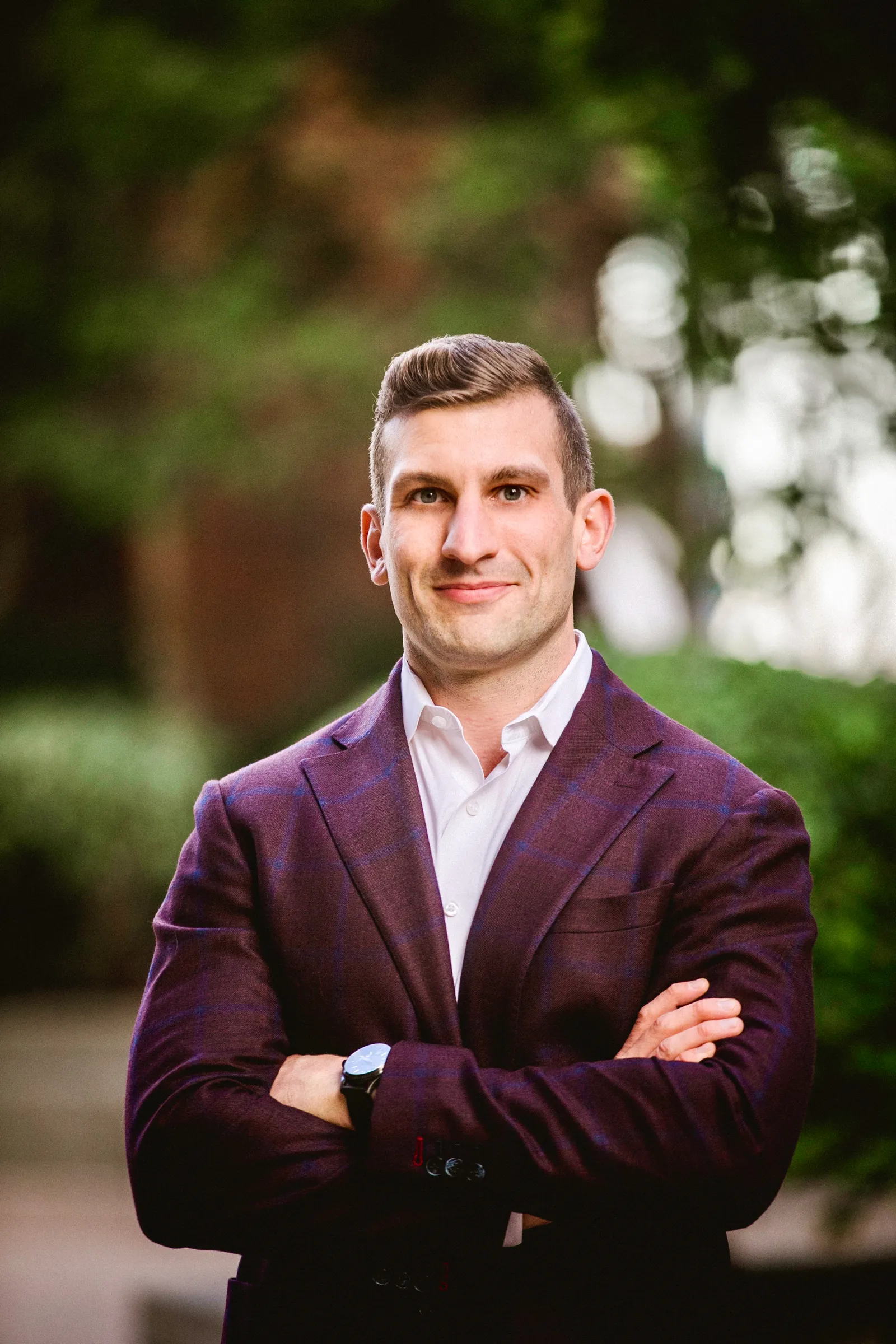 Man in suit jacket standing with arms crossed