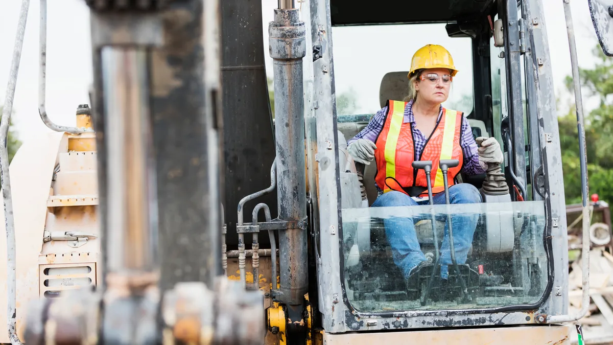 A construction worker operates an earth mover on a construction site.