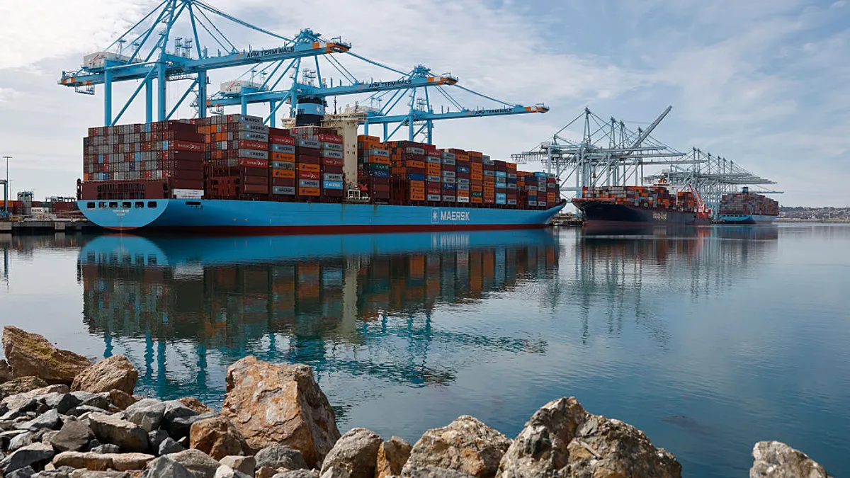 Shipping cranes above cargo vessels at an ocean port.