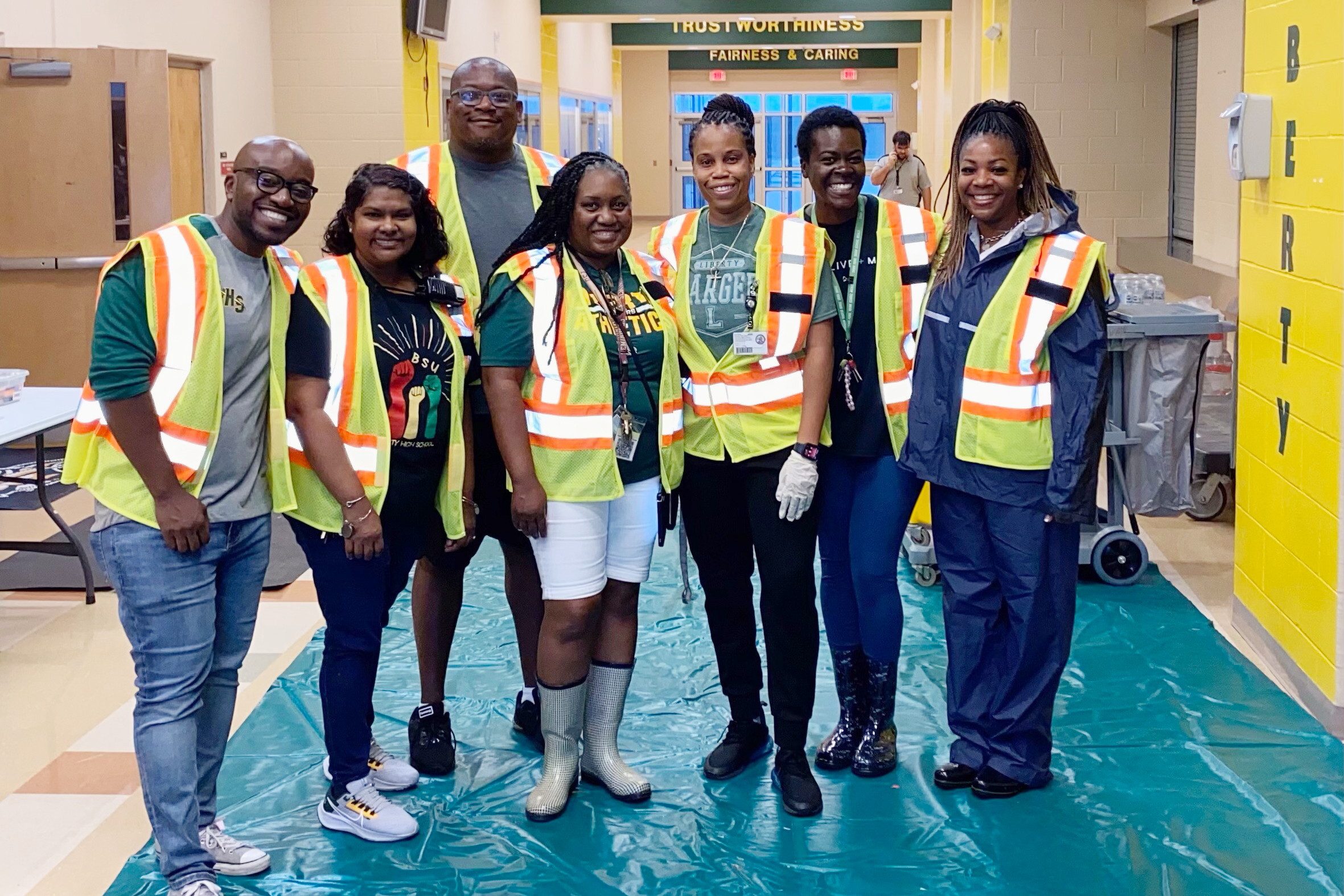 Shelter staff pose in rainboots and wear identifying gear