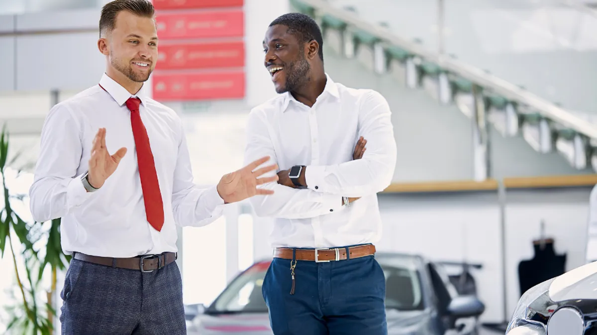 Two salesperson inside a car showroom