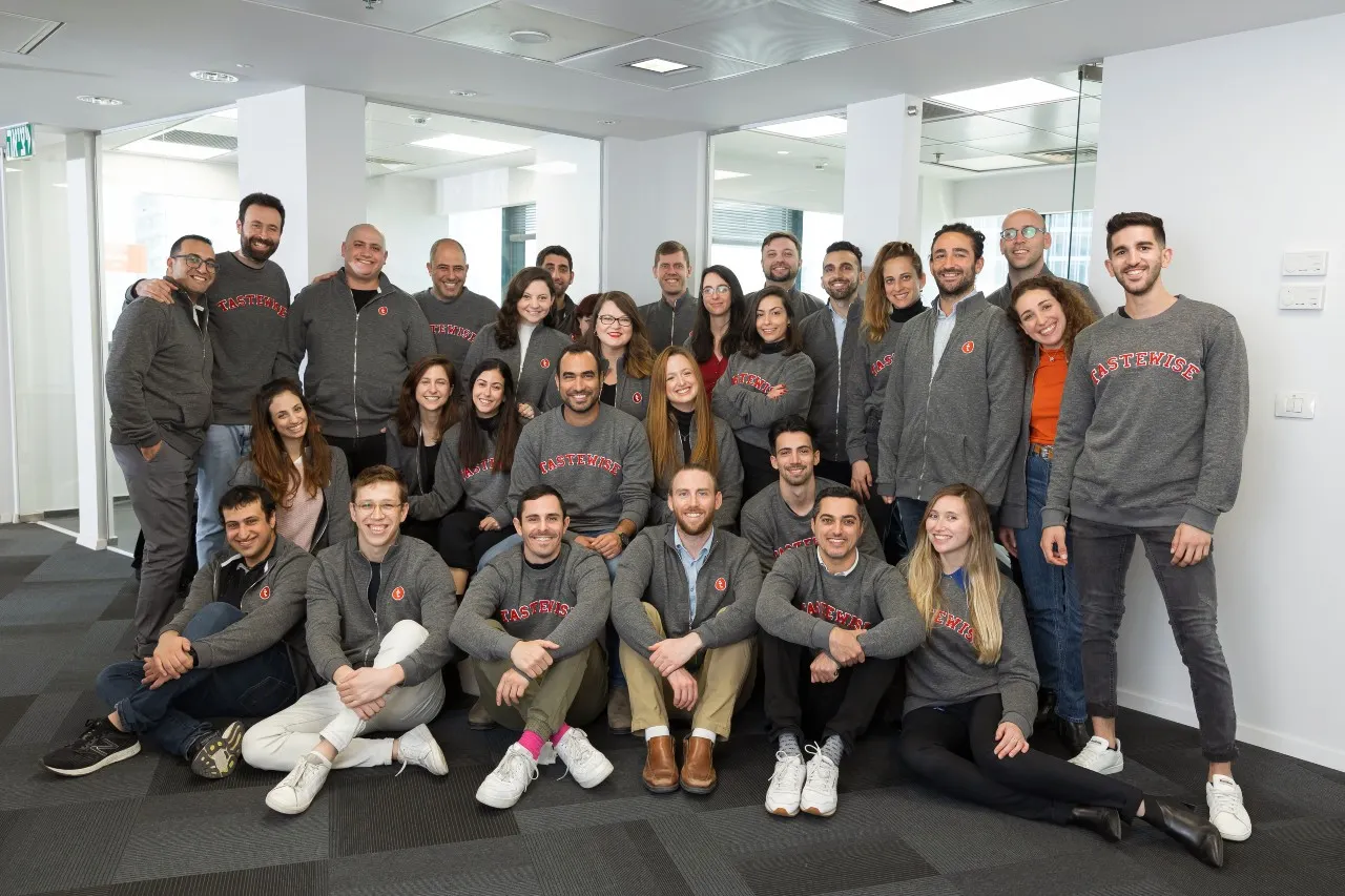 A group of people who work for Tastewise pose in an office.