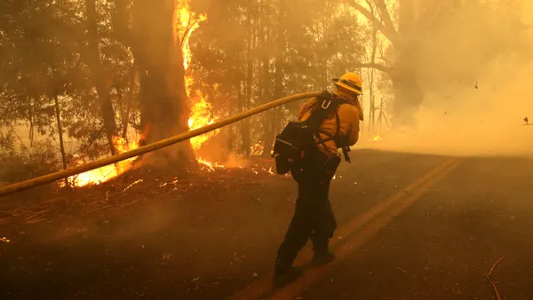 A firefighter pulls a hose.