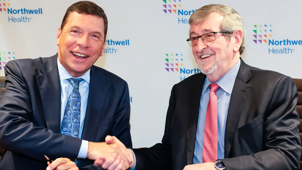 Nuvance Health CEO John M. Murphy, MD, shakes hands with Northwell Health CEO Michael Dowling