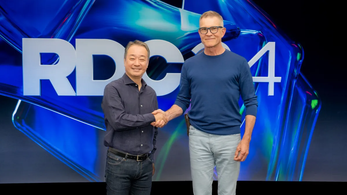 Hiroshi Igarashi, the president and global CEO at Dentsu, shakes hands with David Baszucki, the co-founder and CEO of Roblox.