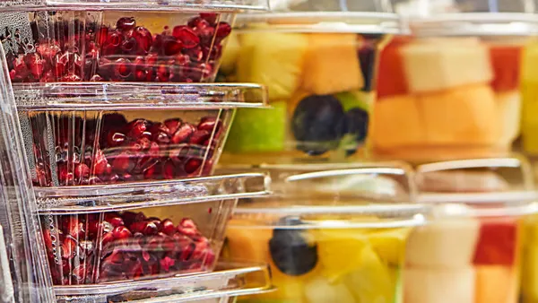 Various fruits inside clear plastic food containers.