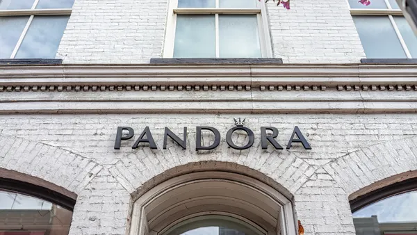 A white brick storefront with arched doorway with a sign that says Pandora