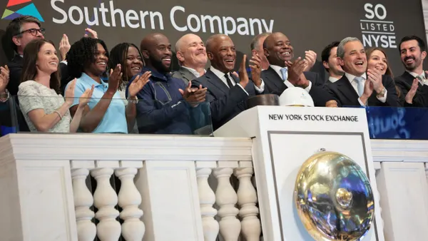 A group of people standing in front of a sign that says "Southern Company"