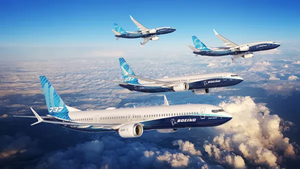 Four planes flying above the clouds with the blue and white Boeing logo on the bottom of the fuselage and the 737 on the rudder.