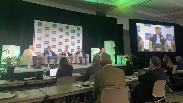 A group of five people sit on stage at WasteExpo 2024