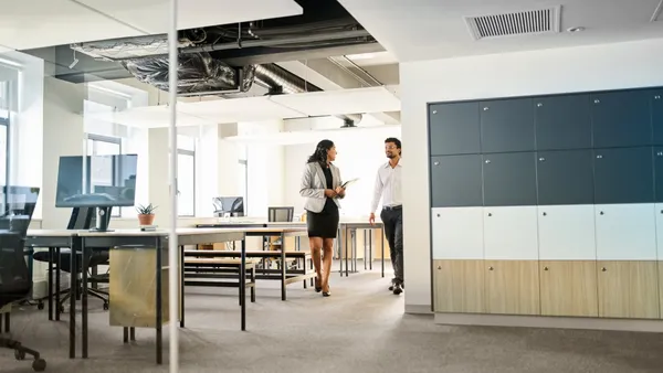 An office real estate agent walks through an empty office with a tenant.