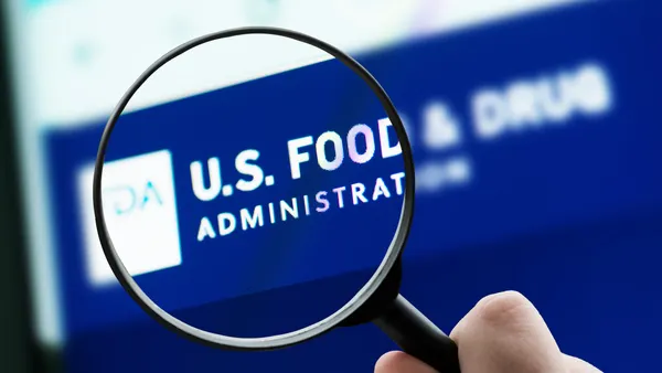 A magnifying glass enlarges the U.S. Food and Drug Administration website on a computer screen.