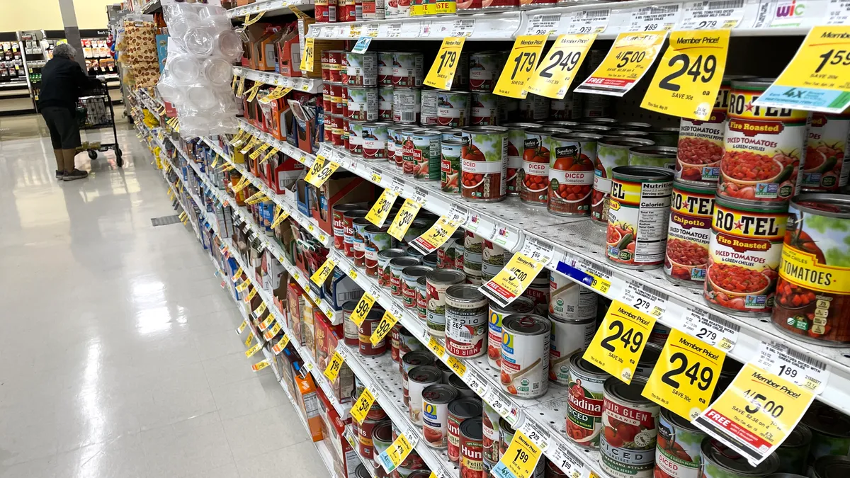 A grocery store aisle with multiple types of canned goods on sale