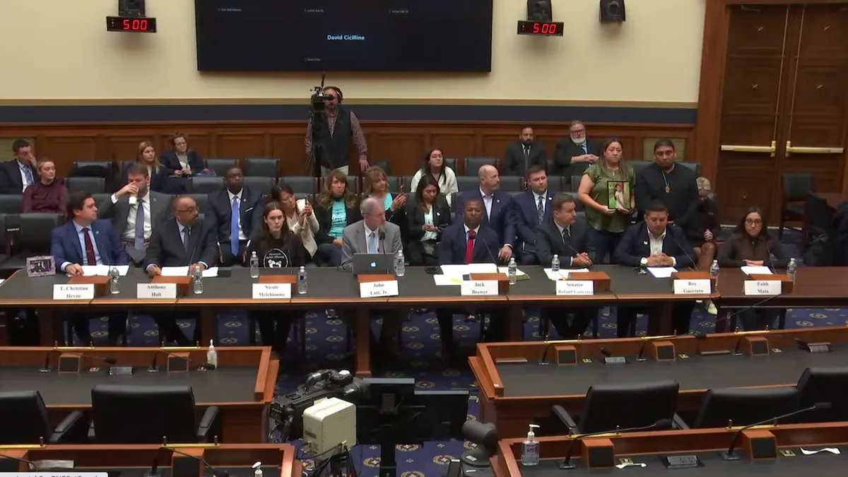 Witnesses face House lawmakers during a hearing on the Uvalde mass shooting in a Congressional committee room.