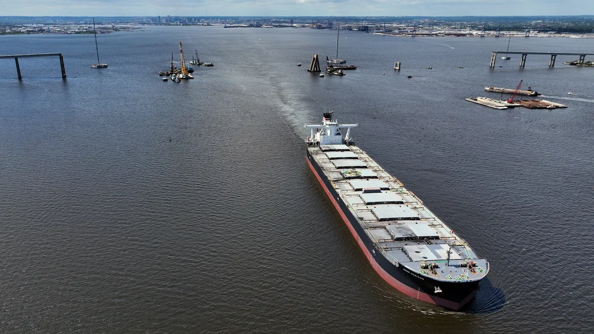 In an aerial view, the Juno Horizon, a Japanese bulk vessel, sails though the cleared Fort McHenry Channel in the Patapsco River on June 11 in Baltimore, Maryland. The federal shipping channel has fully reopened more than two months after the cargo ship Dali hit the Francis Scott Key Bridge, causing it to collapse and cutting off vessel access to the port.