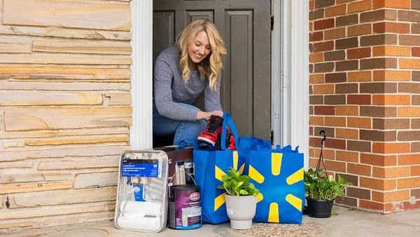 A person brings Walmart bags inside their house.