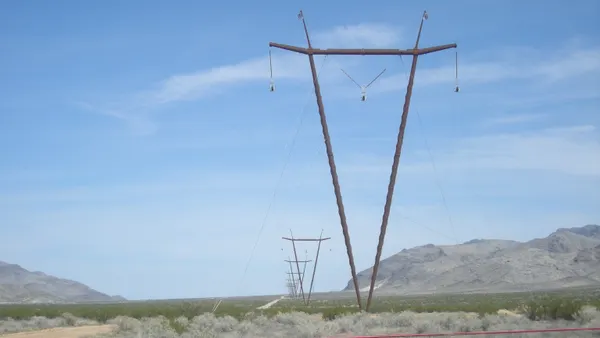 An electric transmission line runs across a desert.