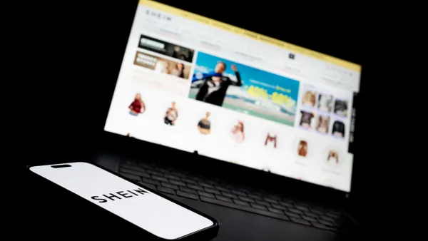 A laptop displaying the Shein website and a phone displaying the Shein logo.