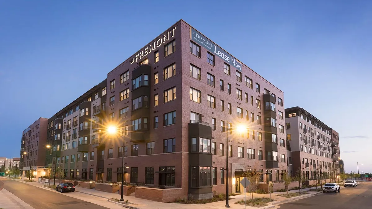 Corner view of a six-story, brick apartment building.