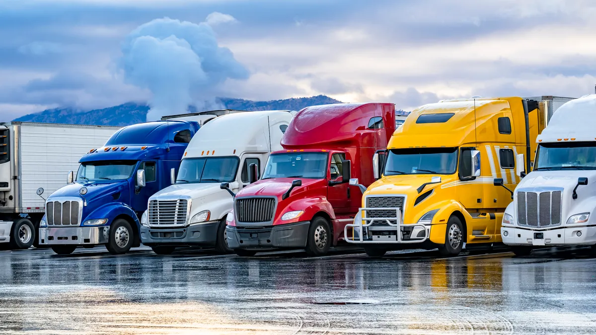 Trucks parked in front of a mountainside.