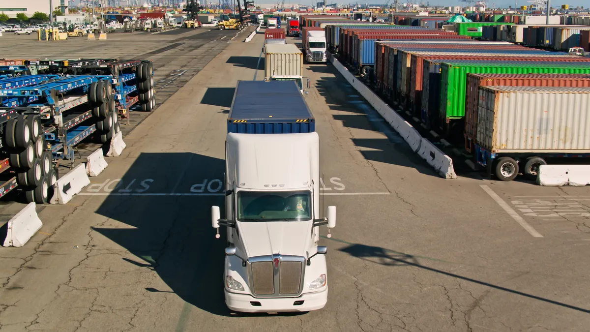 Trucks shown beside intermodal containers lined up at the Port of Los Angeles