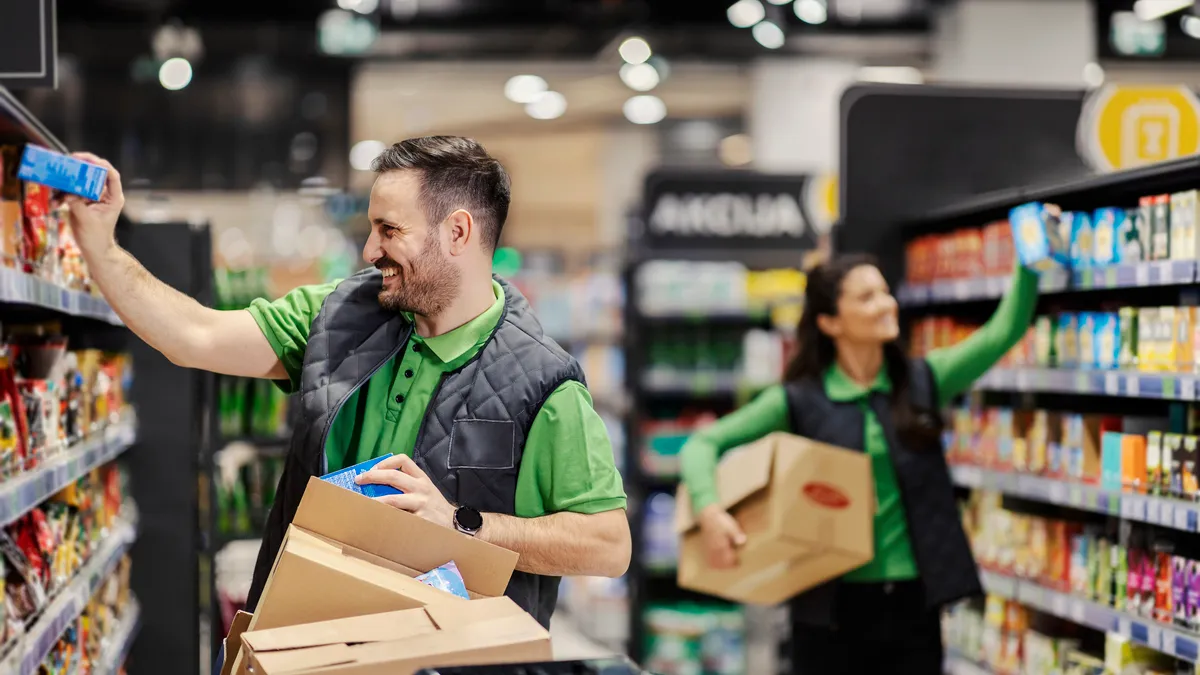 two people stocking shelves