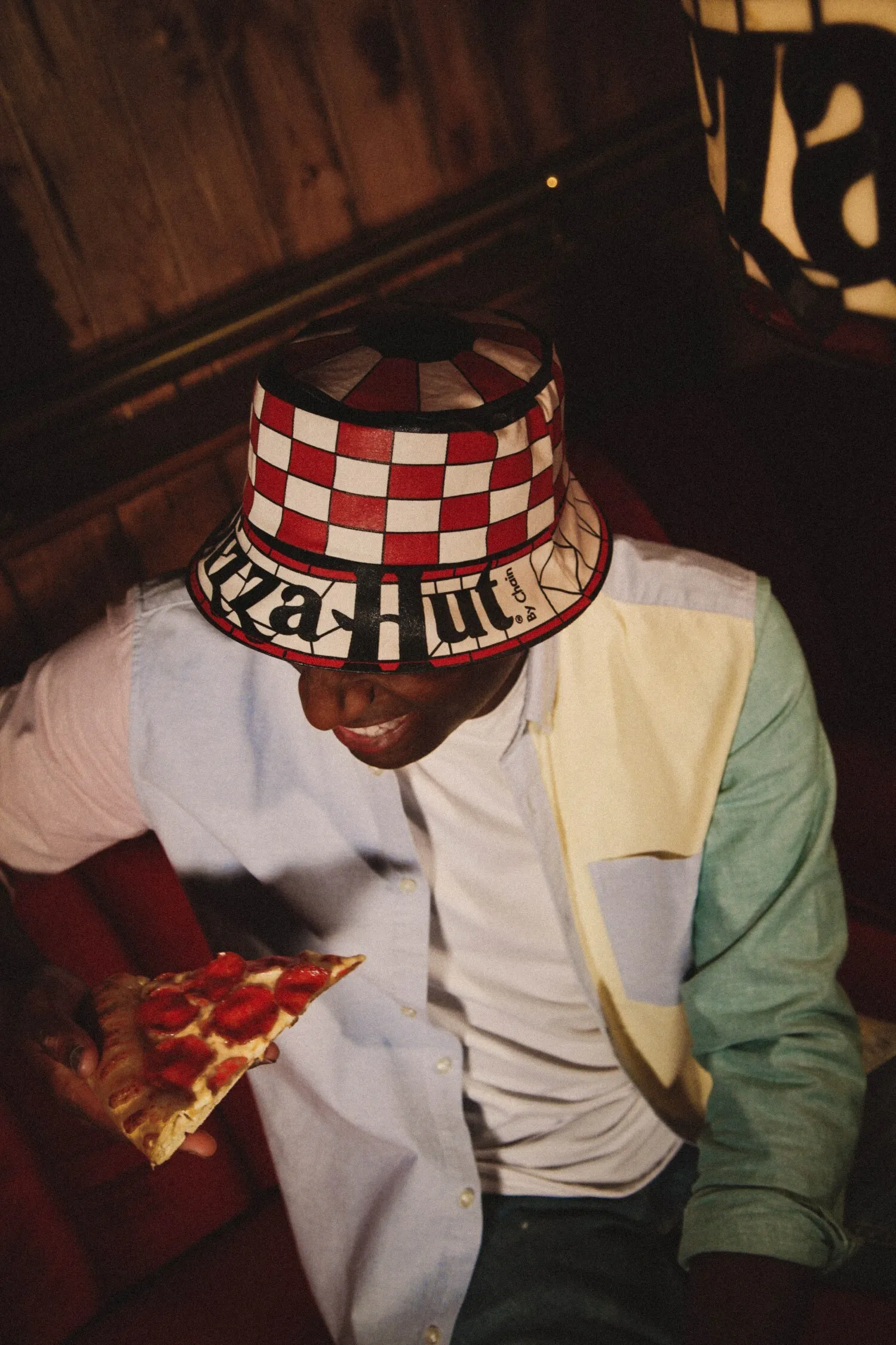 A person smiling wearing a white, black and red bucket hat