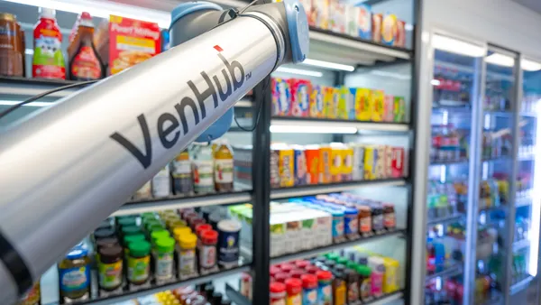 A photo of a robotic arm inside a store. Text on the arm says Venhub.