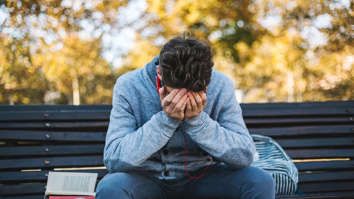 A student sits in a hallway.