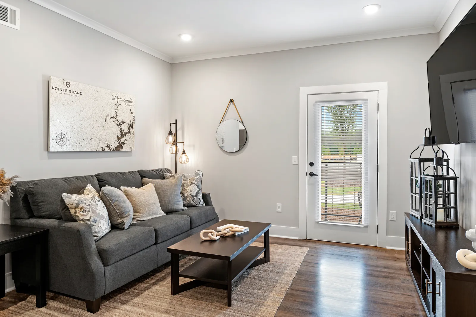 A room with a couch and a door with a window leading outside.