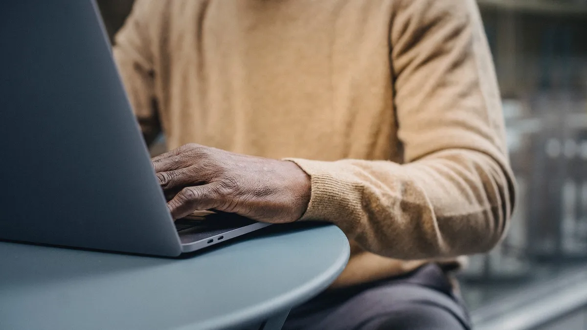 A Black man working on a laptop