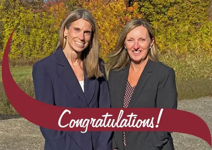 A photo of two people standing outside. White text on a maroon background says &quot;congratulations.&quot;