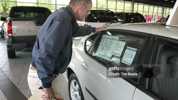 Shopper checks car price tag