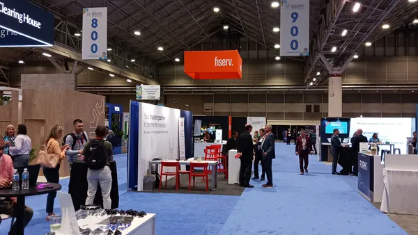 Fiserv sign hangs above conference trade show floor.