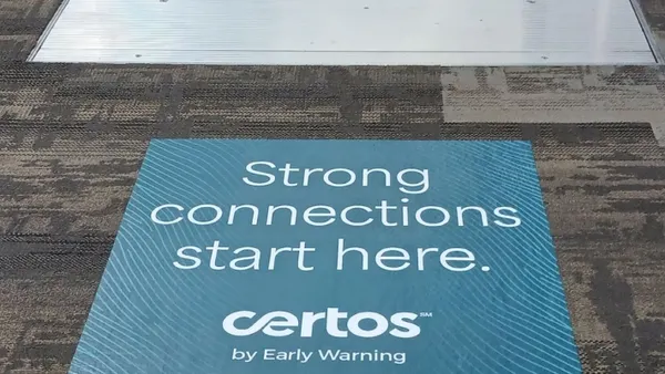 Certos sign attached to carpet in front of escalator.