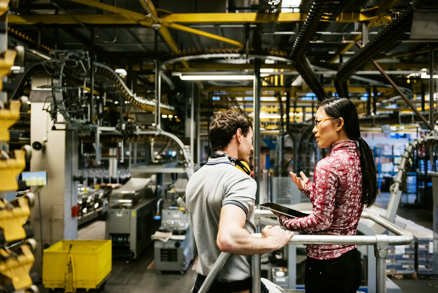 Two people talk in a manufacturing facility.