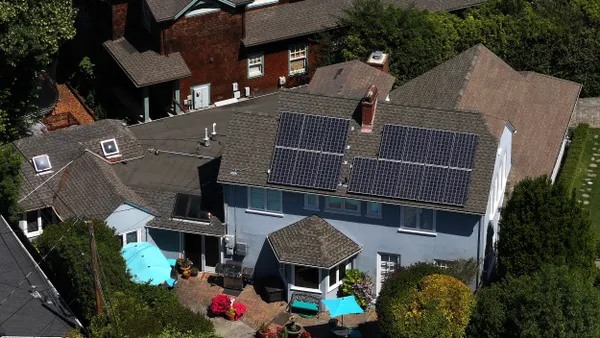 Aerial view of a home with solar panels on the roof and a swimming pool.