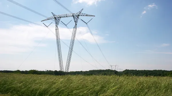 An electric power line crosses a field.